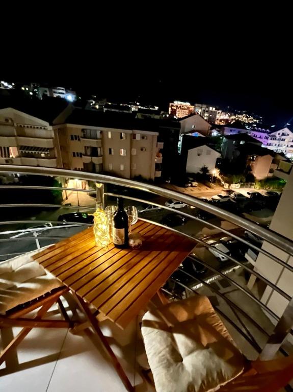 a wooden table on top of a balcony at night at Boutique apartman Dora Yung in Budva