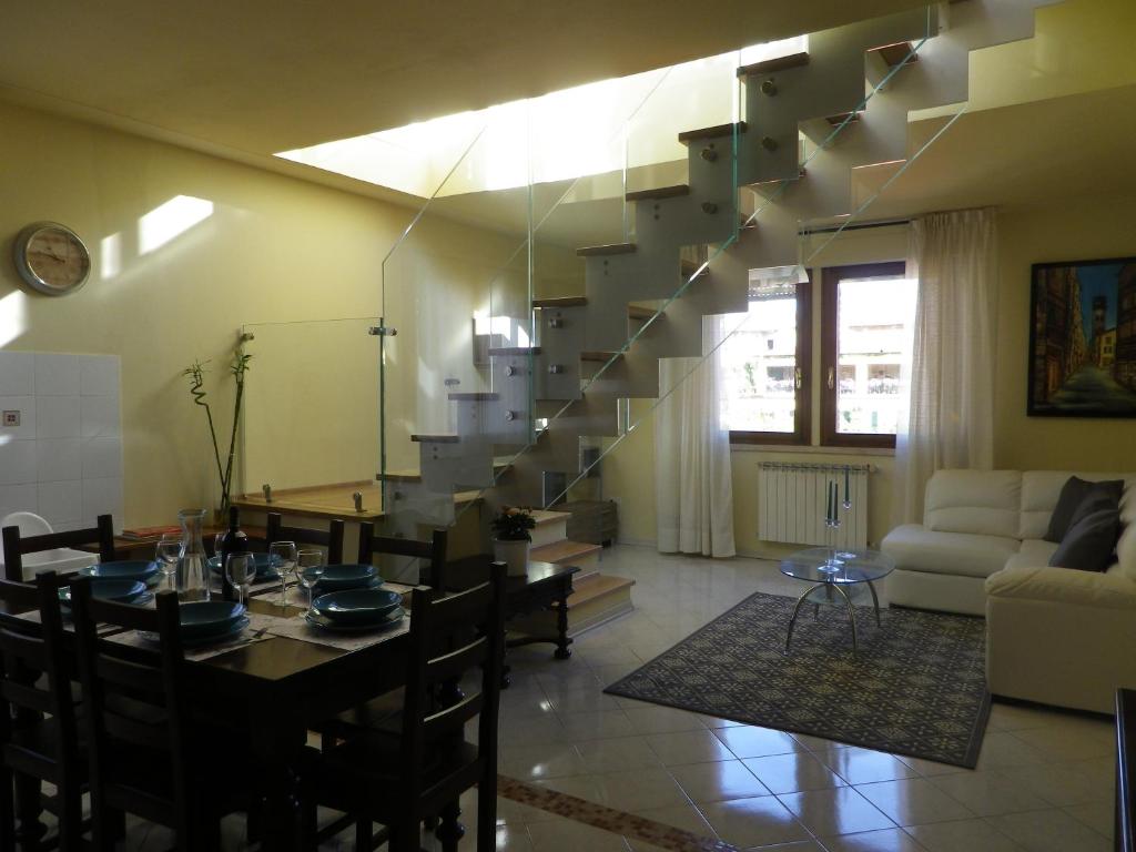 un soggiorno con un tavolo e una scala di La Terrazza a Lucca
