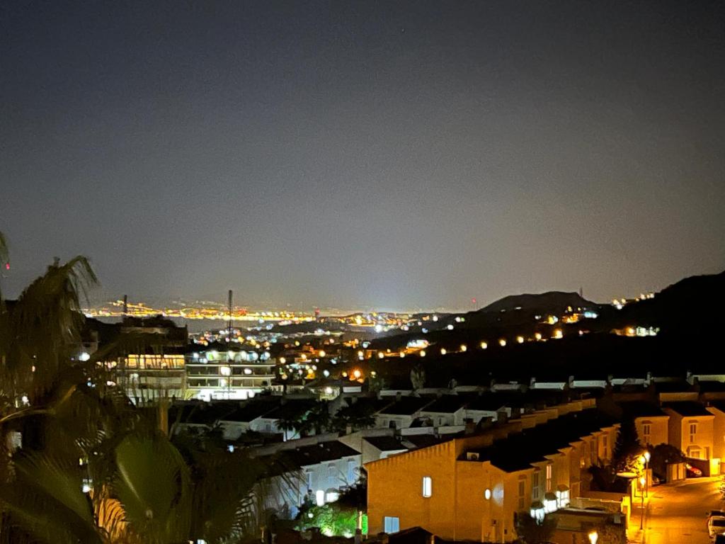 uitzicht op een stad 's nachts met verlichting bij Ático in Málaga