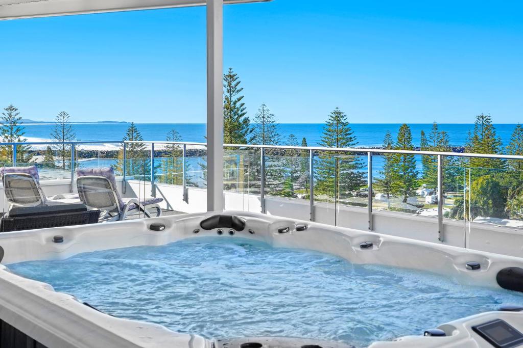 a jacuzzi tub with a view of the ocean at Macquarie Waters Boutique Apartment Hotel in Port Macquarie