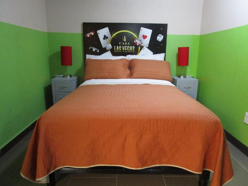 Dormitorio verde con cama con colcha de color naranja en Hermoso Departamento en Texcoco centro con wifi cocina en Texcoco de Mora