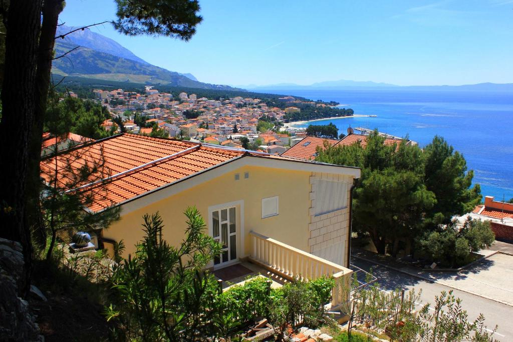 una casa en una colina con vistas al océano en Apartment Baska Voda 10027a, en Baška Voda