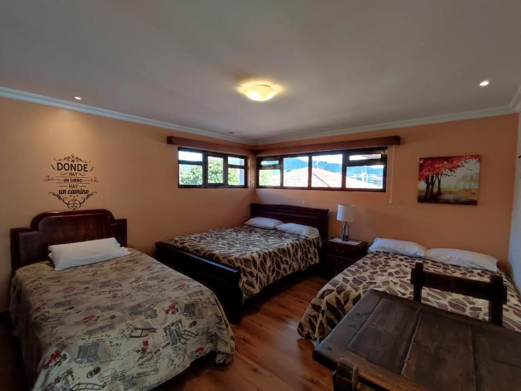 昆卡的住宿－Casatodosantos，客房设有两张床、一张桌子和窗户。