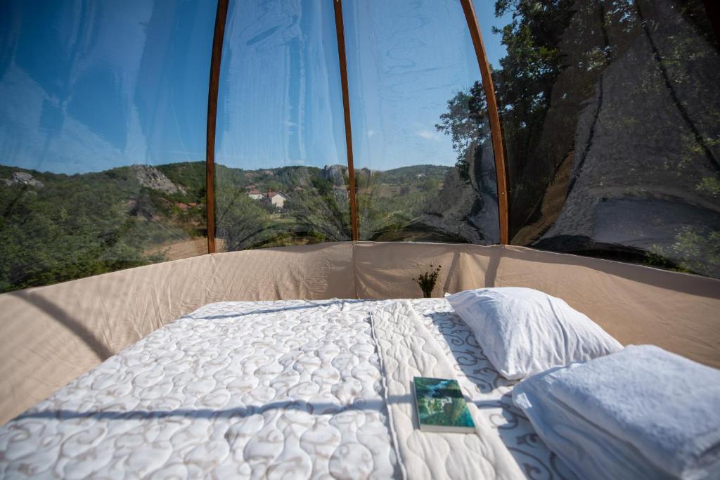 a bed in a room with a large window at Rtanj,Vrmdza,,Hotel sa hiljadu zvezdica" in Soko Banja