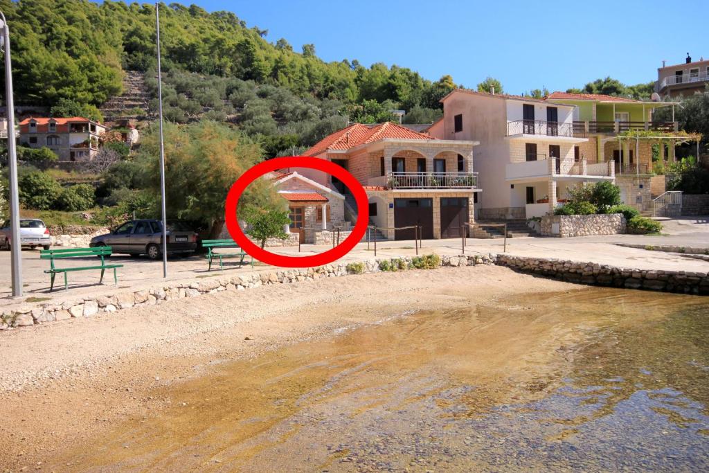 a red circle on a house next to a body of water at Seaside holiday house Grscica, Korcula - 10059 in Prizba