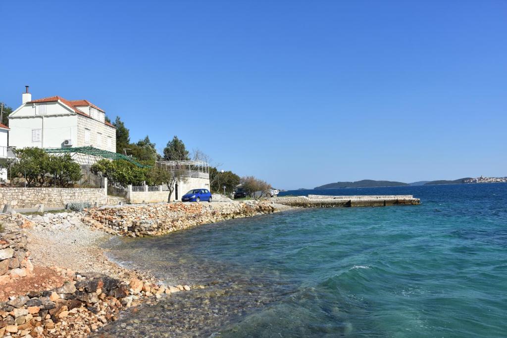 a beach with a house and the water at Apartments by the sea Kuciste, Peljesac - 10095 in Kučište