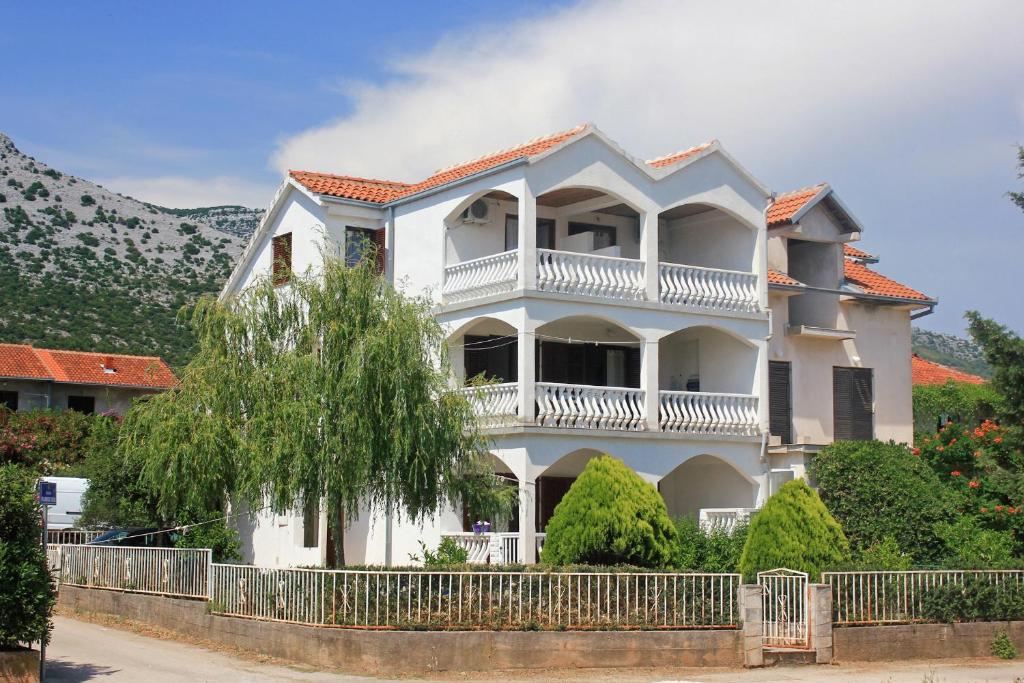 Casa blanca con balcón y árbol en Apartments with a parking space Orebic, Peljesac - 10193, en Orebić