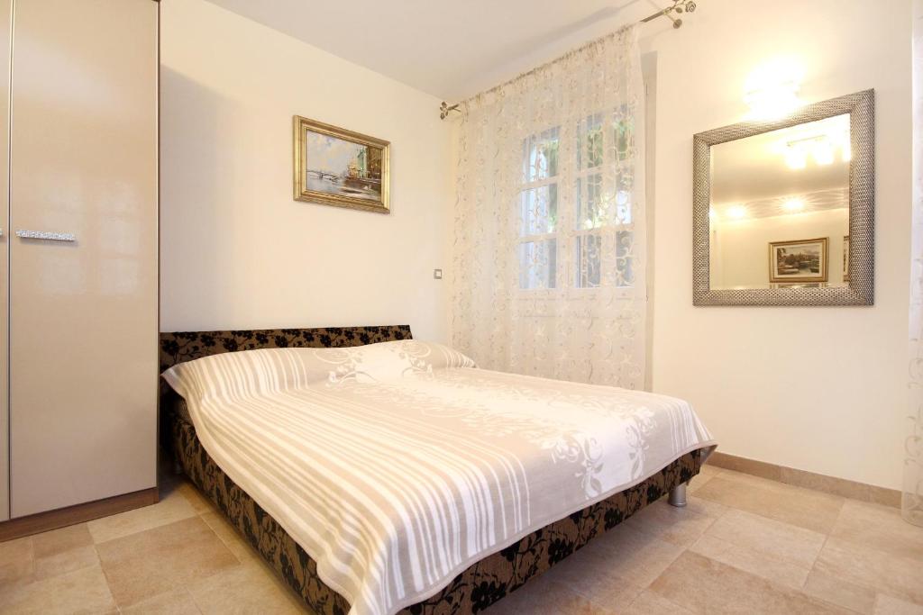 a bed in a bedroom with a mirror on the wall at Apartments by the sea Korcula - 10054 in Korčula