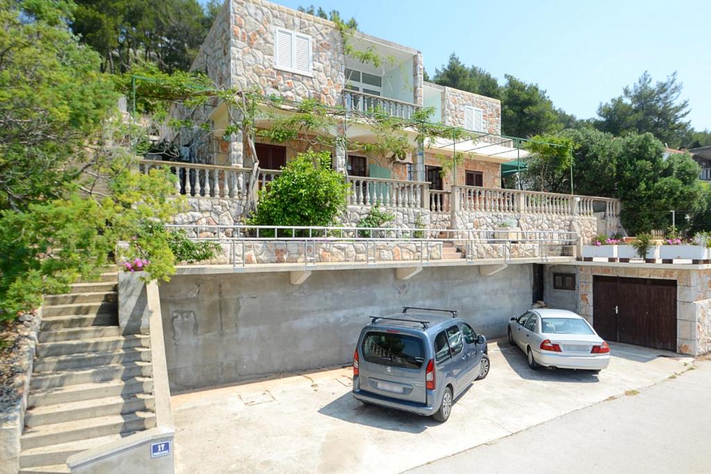 two cars parked in a parking lot in front of a house at Apartment Prizba 10063c in Prizba