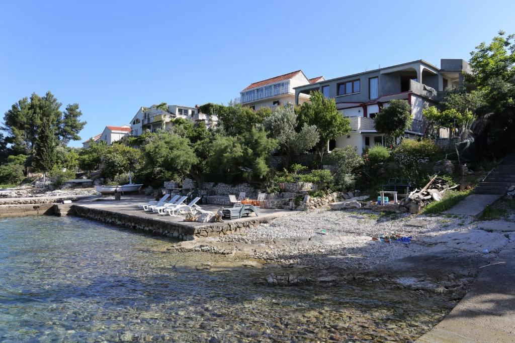 un grupo de sillas en la orilla de un cuerpo de agua en Apartments by the sea Korcula - 10041 en Korčula