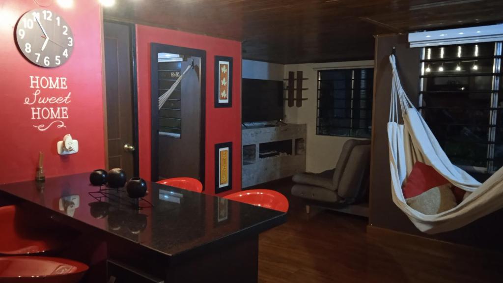 un bar con sillas rojas y un reloj en la pared en Hermoso acogedor y hogareño apartamento duplex tipo loft suba la campiña, en Bogotá