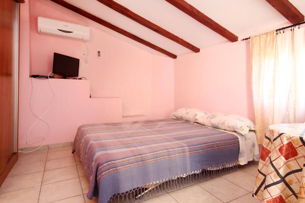 a bedroom with a bed and a television in it at Apartments by the sea Orebic, Peljesac - 10094 in Orebić