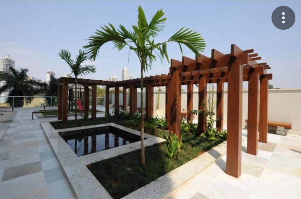 a patio with a pool and a wooden pergola at Lindo flat Easy Life in Goiânia