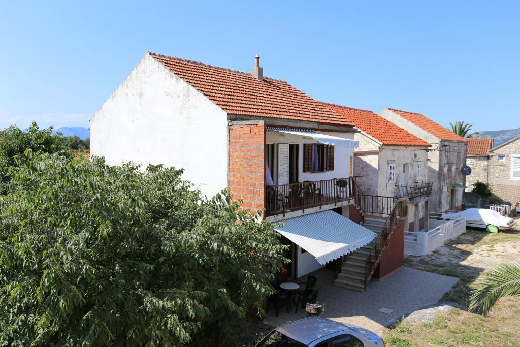 Dieses weiße Haus verfügt über eine Veranda und einen Balkon. in der Unterkunft Apartments by the sea Sreser, Peljesac - 10227 in Janjina