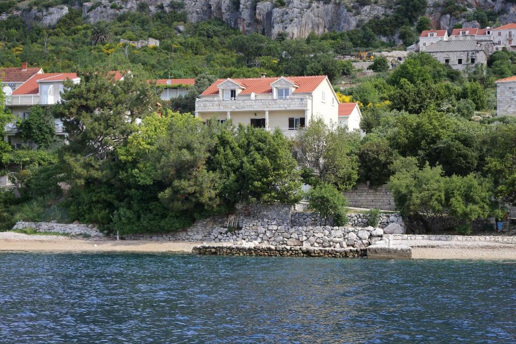 ein Haus am Ufer eines Wasserkörpers in der Unterkunft Apartments by the sea Viganj, Peljesac - 10116 in Viganj