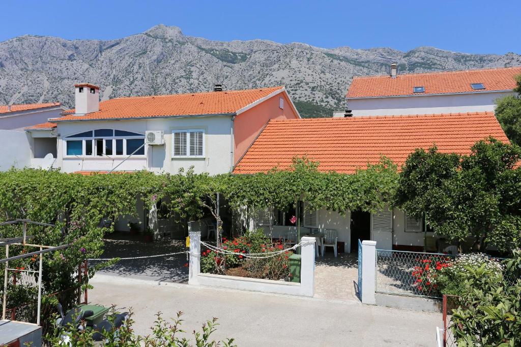 une maison avec une clôture et un bouquet de raisins dans l'établissement Apartments with a parking space Orebic, Peljesac - 10149, à Orebić