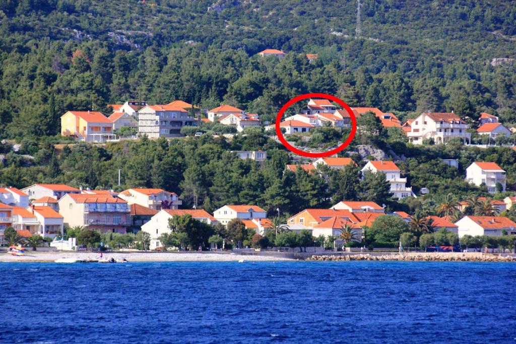 a group of houses on a beach with a red circle at Apartments with parking space Orebic, Peljesac - 10173 in Orebić