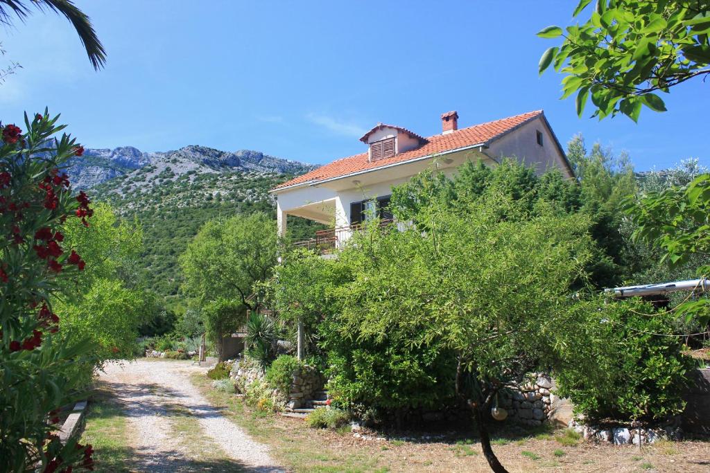 a house on the side of a road with trees at Apartments with a parking space Orebic, Peljesac - 10178 in Orebić
