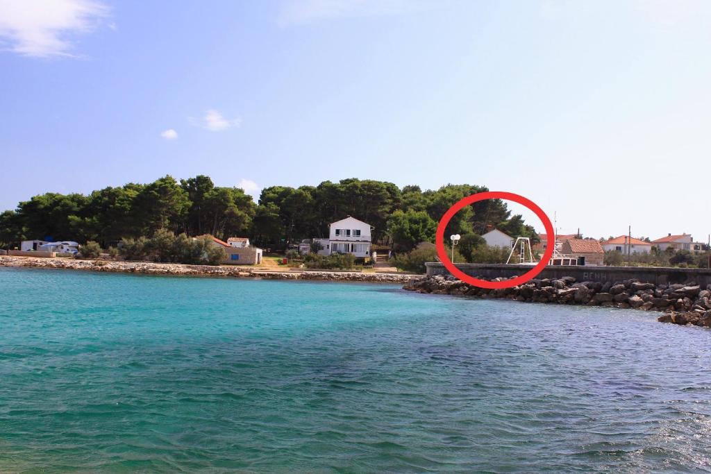 ein roter Kreis am Ufer eines Wasserkörpers liegt in der Unterkunft Seaside holiday house Susica, Ugljan - 9664 in Ugljan