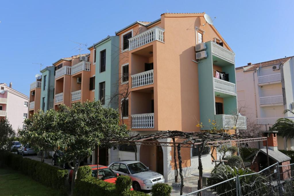 波茲塔納的住宿－Apartments by the sea Podstrana, Split - 9503，前面有汽车停放的建筑