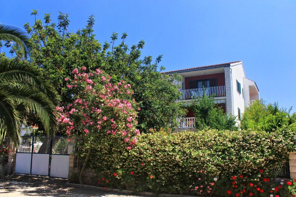 een huis met roze bloemen voor een hek bij Apartments by the sea Loviste, Peljesac - 10182 in Lovište