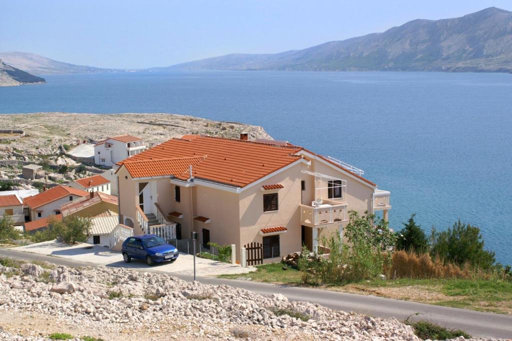 una casa sul fianco di una collina vicino all'acqua di Apartments by the sea Zubovici, Pag - 9678 a Zubovići