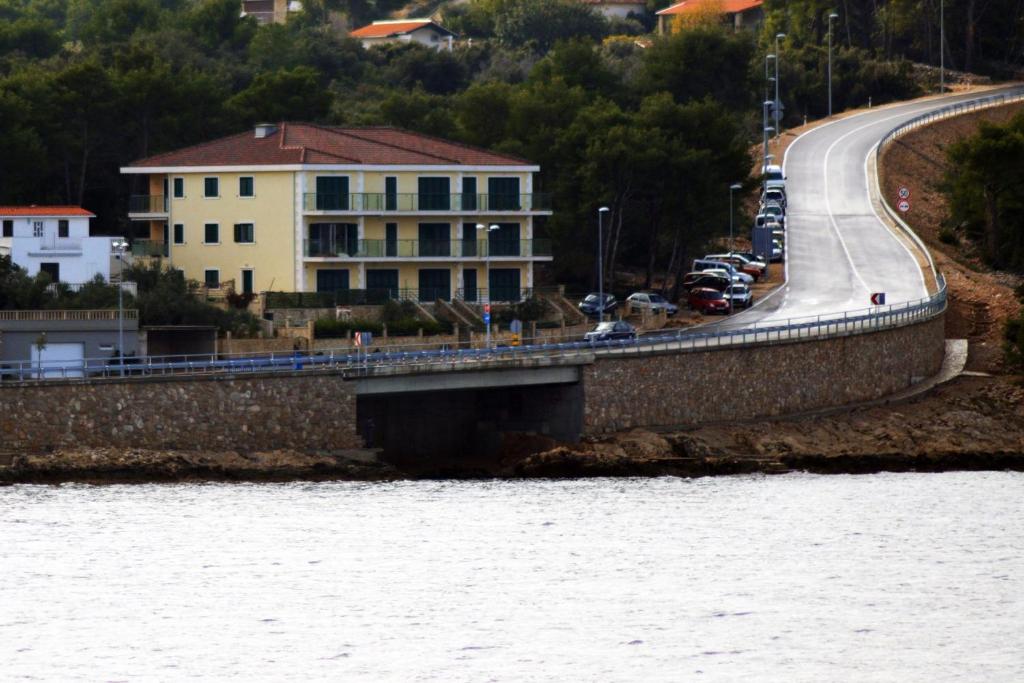 eine Brücke über einen Wasserkörper neben einem Gebäude in der Unterkunft Apartments by the sea Rogac, Solta - 11655 in Grohote