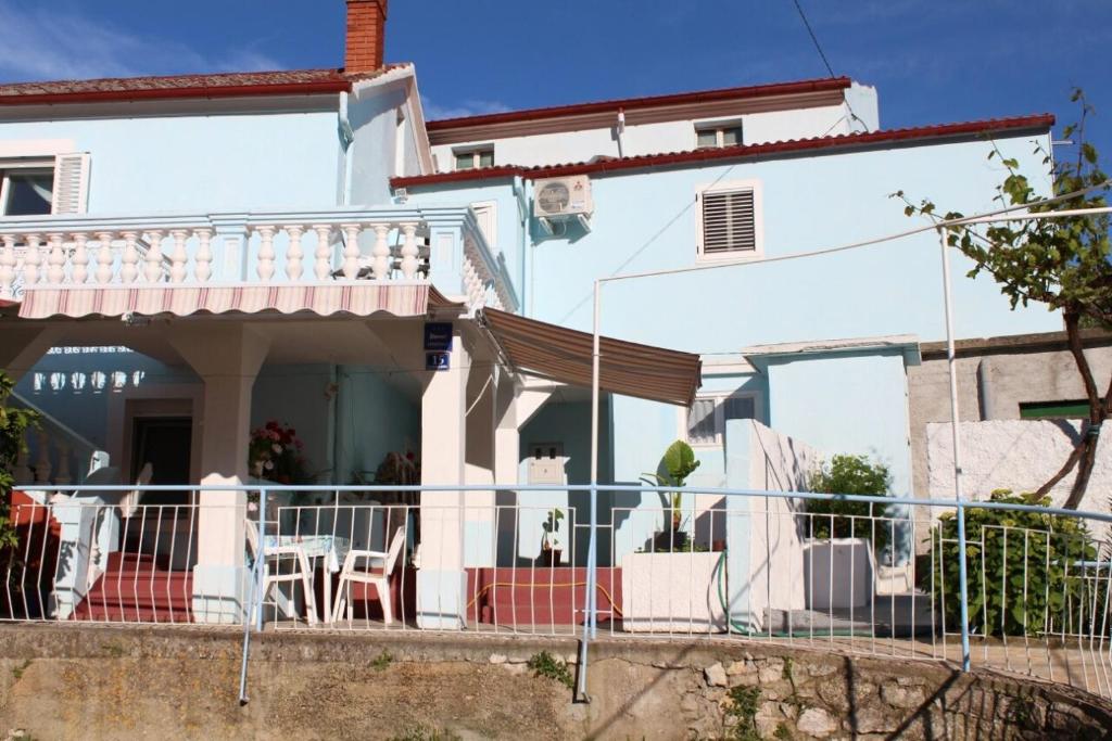 uma casa branca com uma varanda e uma mesa em Apartment Lukoran 11672a em Lukoran