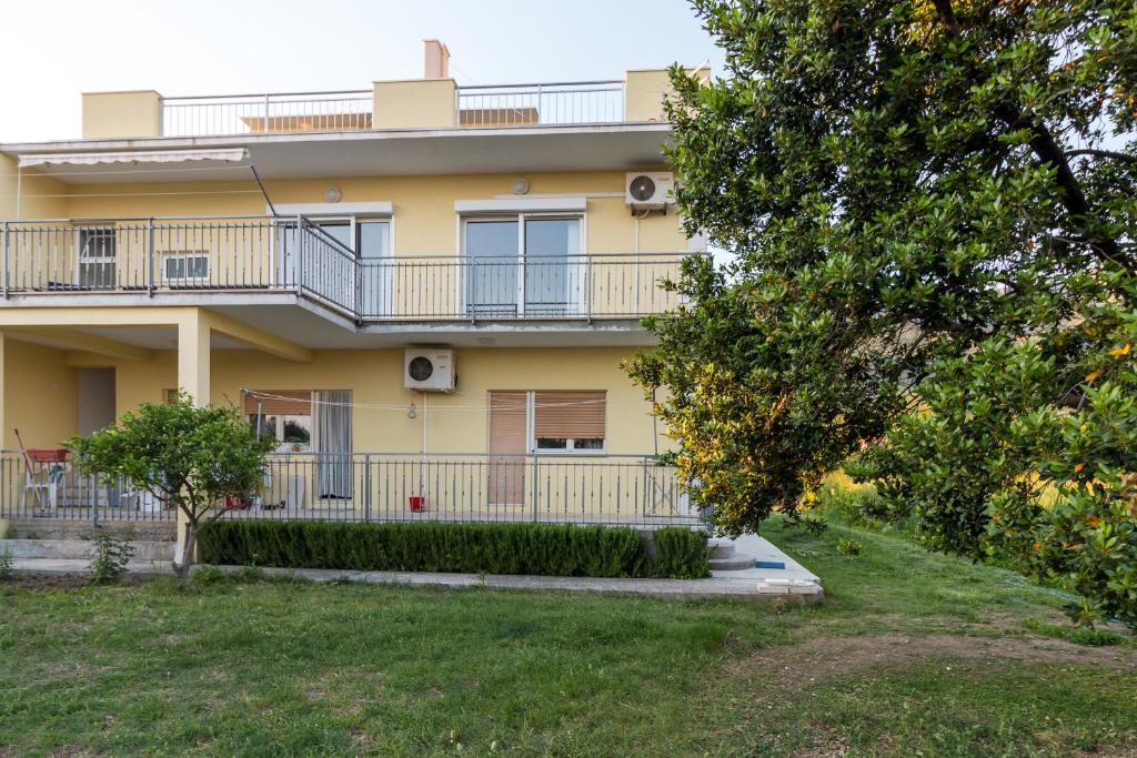 ein gelbes Gebäude mit einem Balkon und einem Hof in der Unterkunft Apartments with a parking space Kastel Kambelovac, Kastela - 11678 in Kaštela