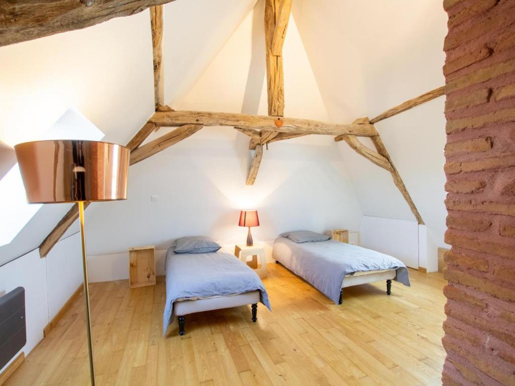 Habitación con 2 camas, suelo y vigas de madera. en Gîte Saint-Pierre-de-Chignac, 6 pièces, 11 personnes - FR-1-616-221, en Saint-Pierre-de-Chignac