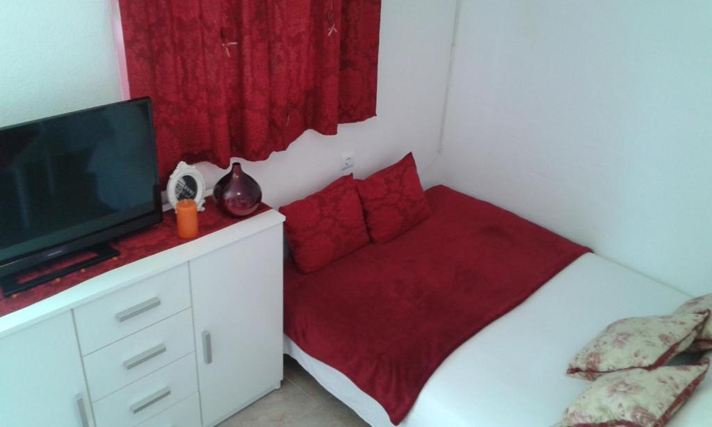 ein kleines Schlafzimmer mit einem Bett und einem TV in der Unterkunft Apartments with a parking space Kastel Kambelovac, Kastela - 11755 in Kaštela