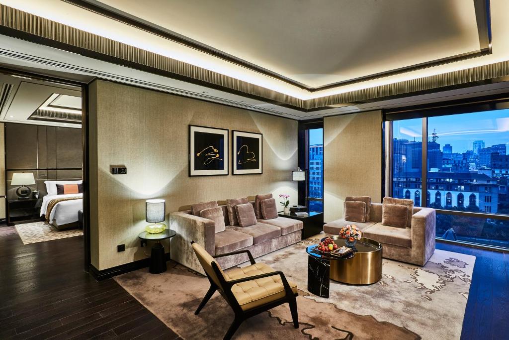 ein Wohnzimmer mit einem Sofa und einem Bett in der Unterkunft Bellagio by MGM Shanghai - on the bund in Shanghai