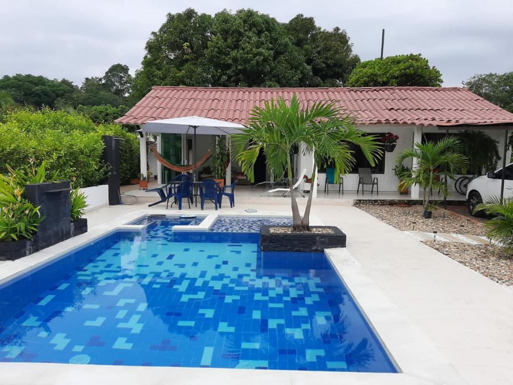 a swimming pool in front of a house at Casa campestre melgar herradura con piscina privada in Melgar