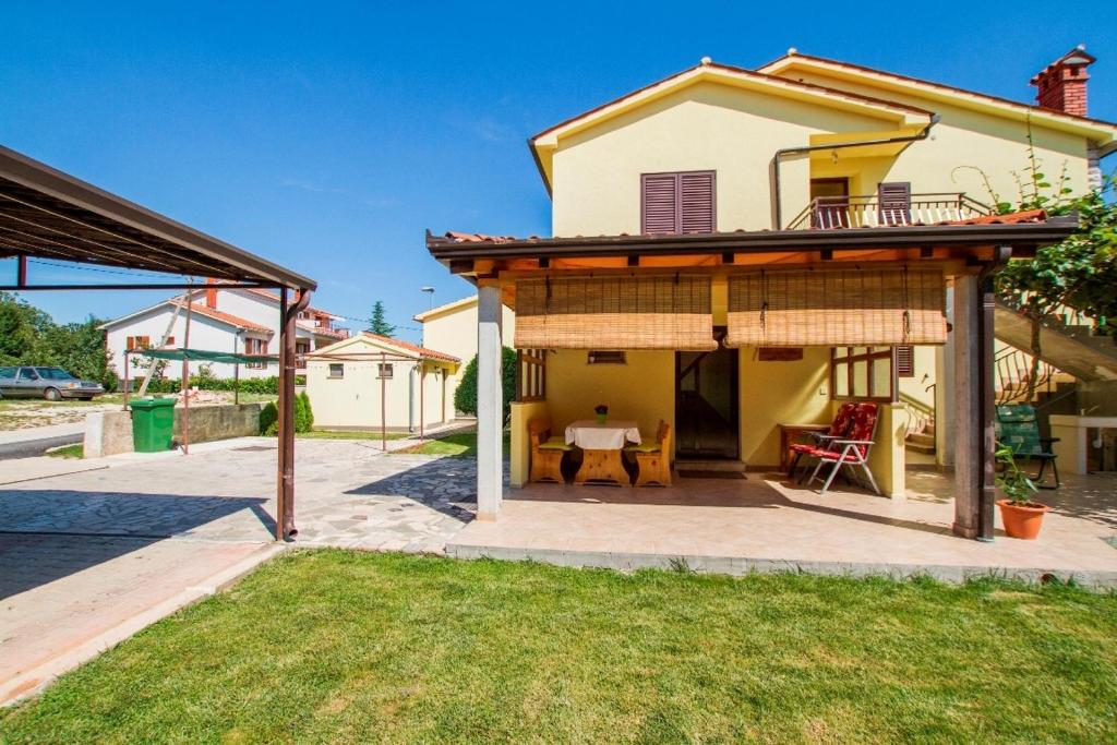 a house with a patio with a roof at Apartments with a parking space Vinez, Labin - 11851 in Labin