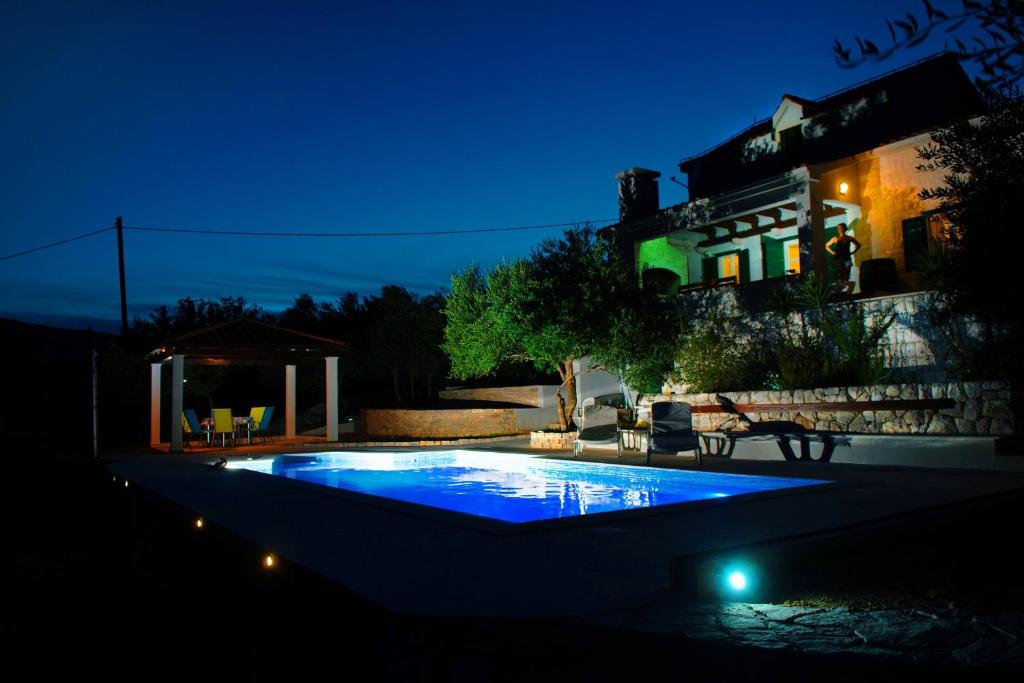 a swimming pool in a yard at night at Holiday house with a swimming pool Plano, Trogir - 11897 in Kastel Stafilic