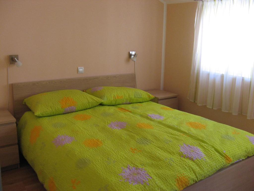 a bedroom with a green comforter and two pillows on a bed at Holiday house with WiFi Susak, Losinj - 11911 in Susak