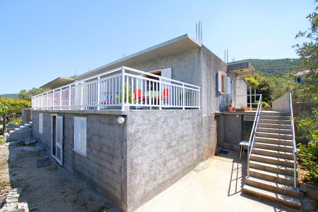 ein Haus mit einem Balkon an der Seite in der Unterkunft Apartments by the sea Zuronja, Peljesac - 12020 in Putniković