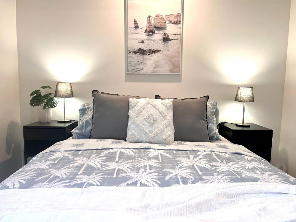 a bedroom with a white bed with two lamps at Husky Sol in Huskisson