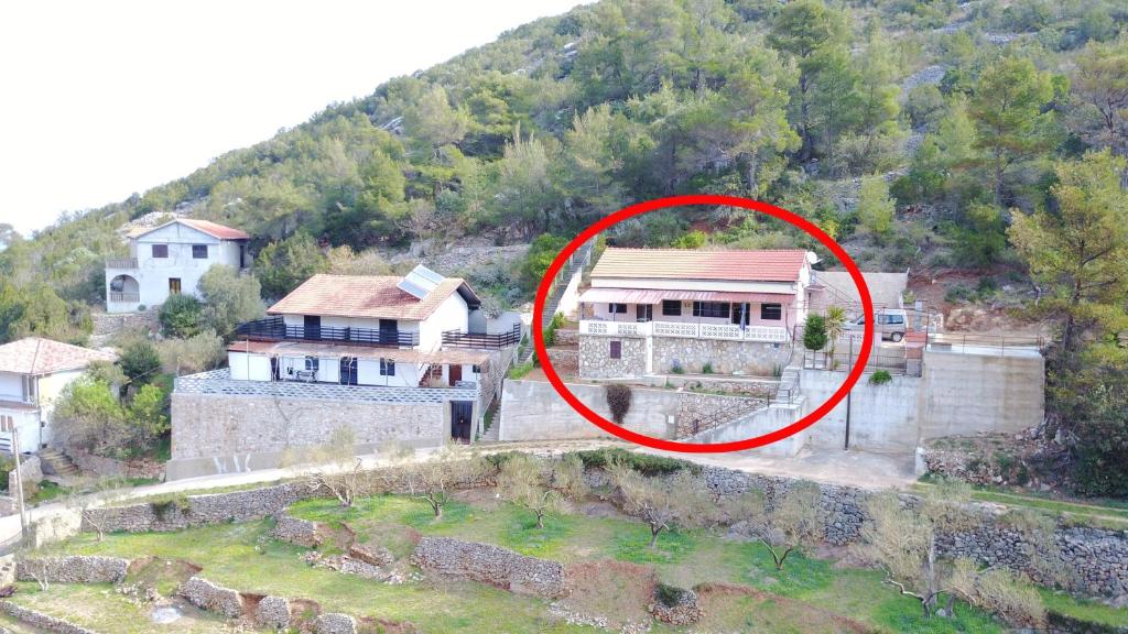 dom z czerwonym krągiem przed nim w obiekcie Apartments by the sea Cove Prapratna - Prapatna (Hvar) - 12207 w mieście Jelsa