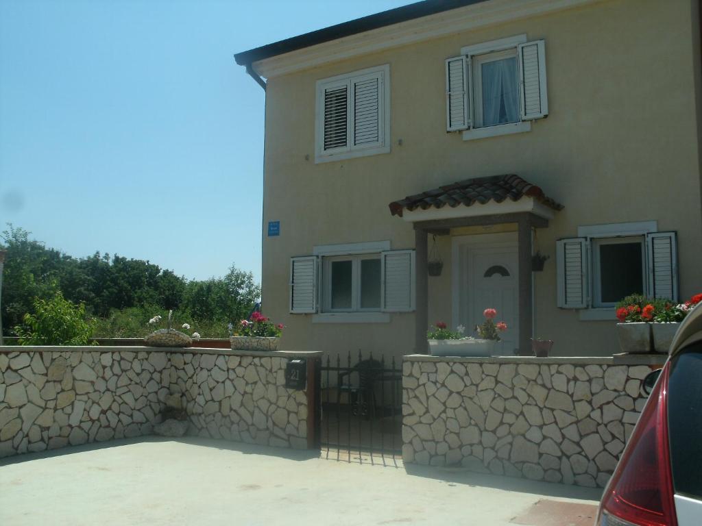 a large house with a stone wall and a driveway at Apartments for families with children Sisan, Medulin - 12199 in Ližnjan