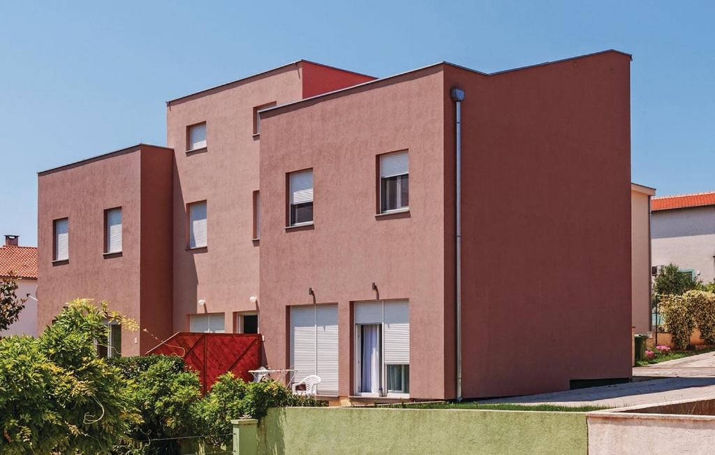 ein großes Backsteingebäude mit einem roten in der Unterkunft Apartments with a parking space Zadar - 12203 in Zadar