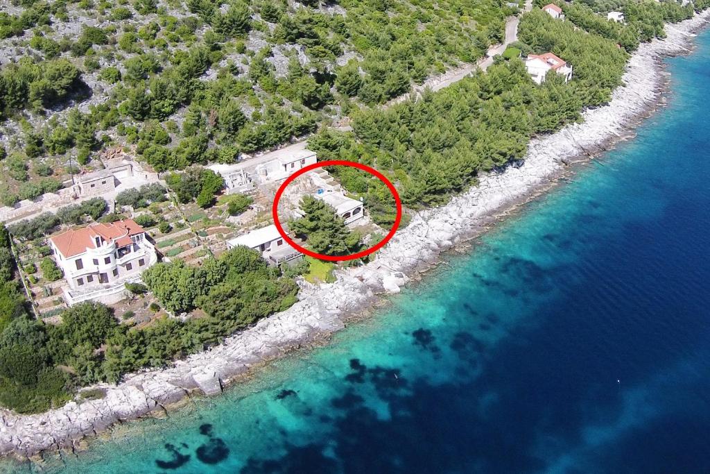 an island with a house in the middle of the water at Apartments by the sea Cove Zaglav, Korcula - 12208 in Prizba