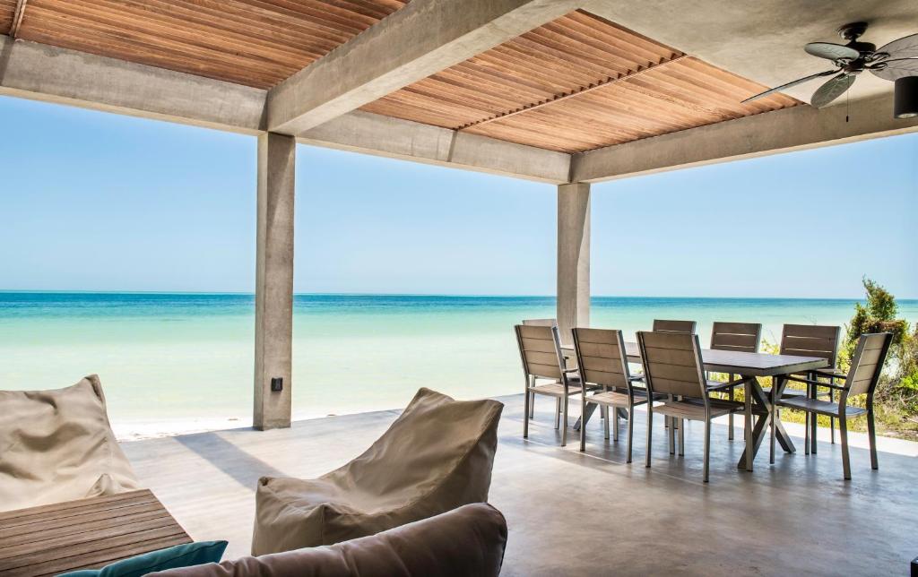 a patio with a table and chairs on the beach at Casa Gonza Holbox in Holbox Island