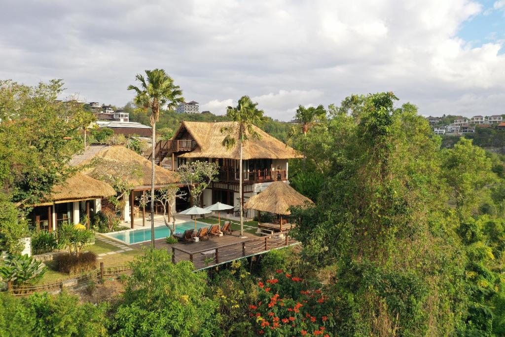 eine Luftansicht eines Hauses mit Pool und Bäumen in der Unterkunft Jimbaran Beach Villas by Nakula in Jimbaran