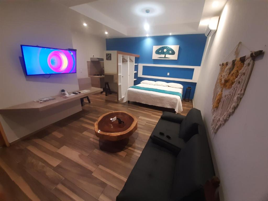 - une chambre avec un lit et une télévision murale dans l'établissement Hotel Boutique Casa Mariano, à Tepic