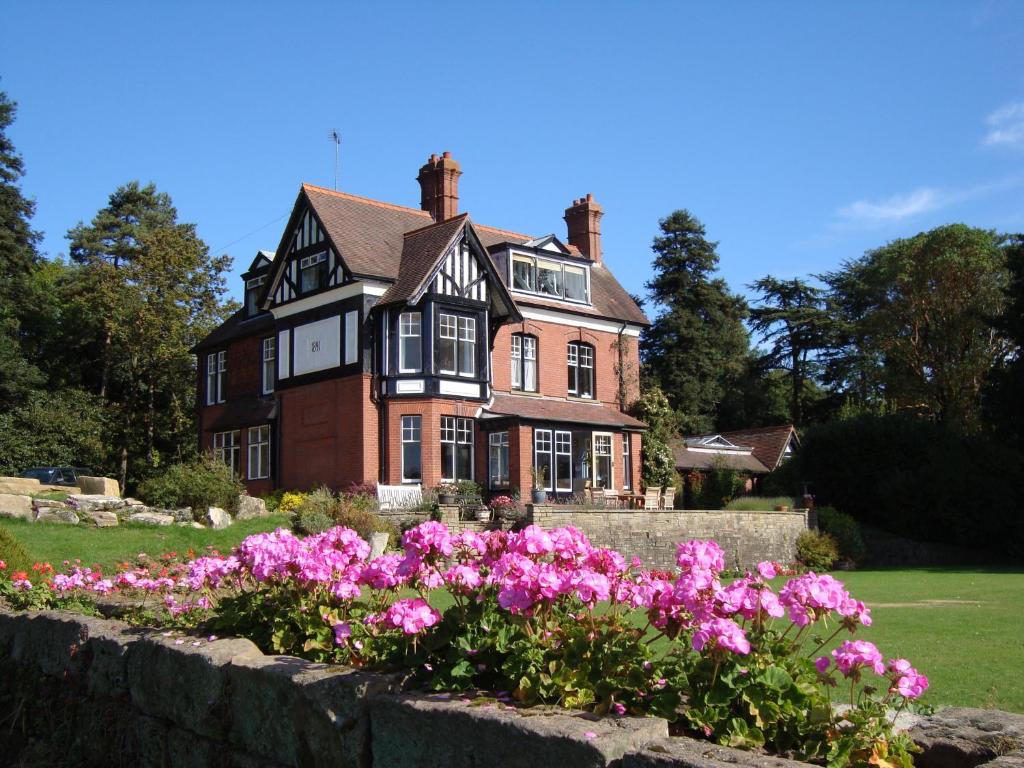 a house with pink flowers in front of it at Woodlands Bed & Breakfast in Barnt Green