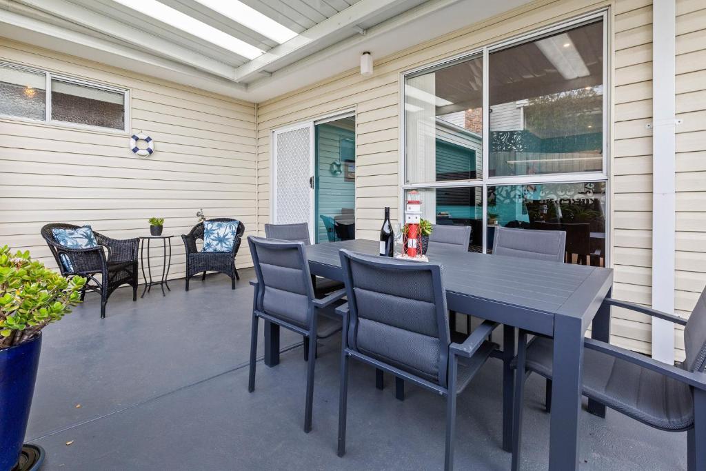 a patio with a table and chairs on a porch at SEArenity in Rosebud