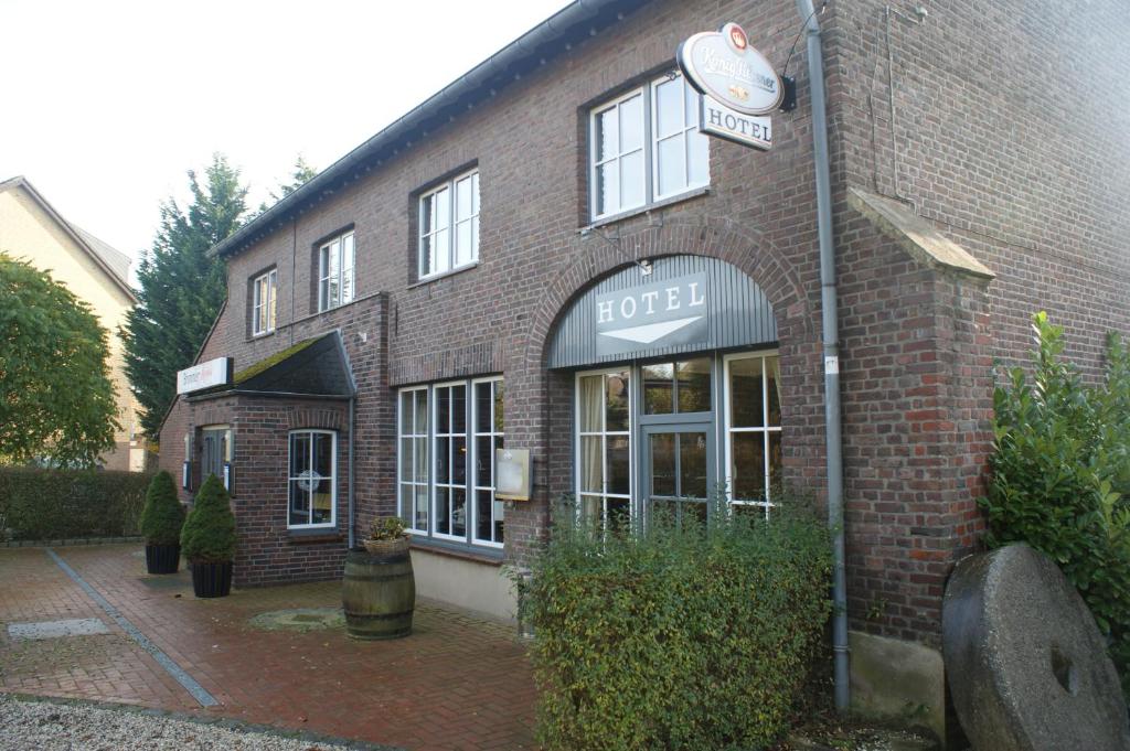 een bakstenen gebouw met een hotelbord erop bij Brommler Mühle in Gangelt