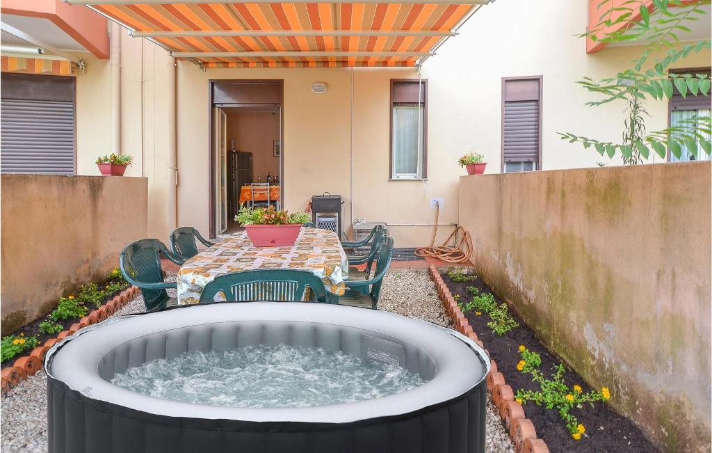 una bañera de hidromasaje en un patio con mesa y sillas en Stunning Home In Motta Camastra With Kitchen, en Motta Camastra