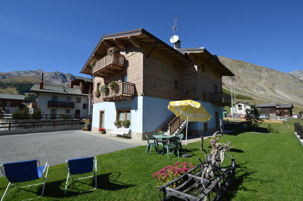 a house with a table and chairs in the yard at Casa Fiorella in Livigno